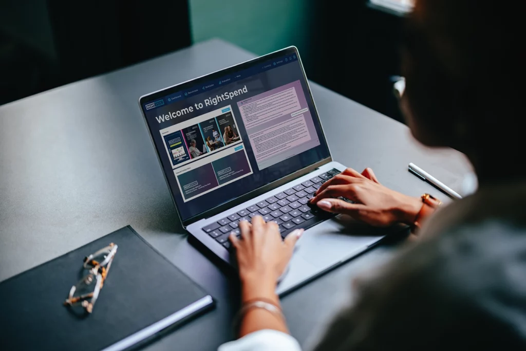 Hands on an open laptop with RightSpend on the screen showing your data-driven marketing procurement platform