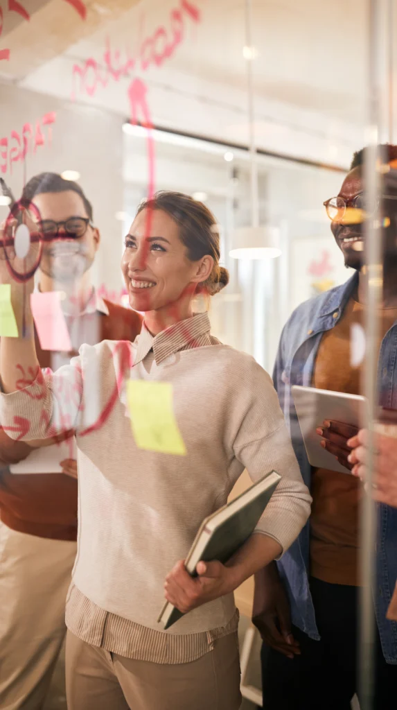Marketing Procurement team working on a glass screen to identify team efficiencies
