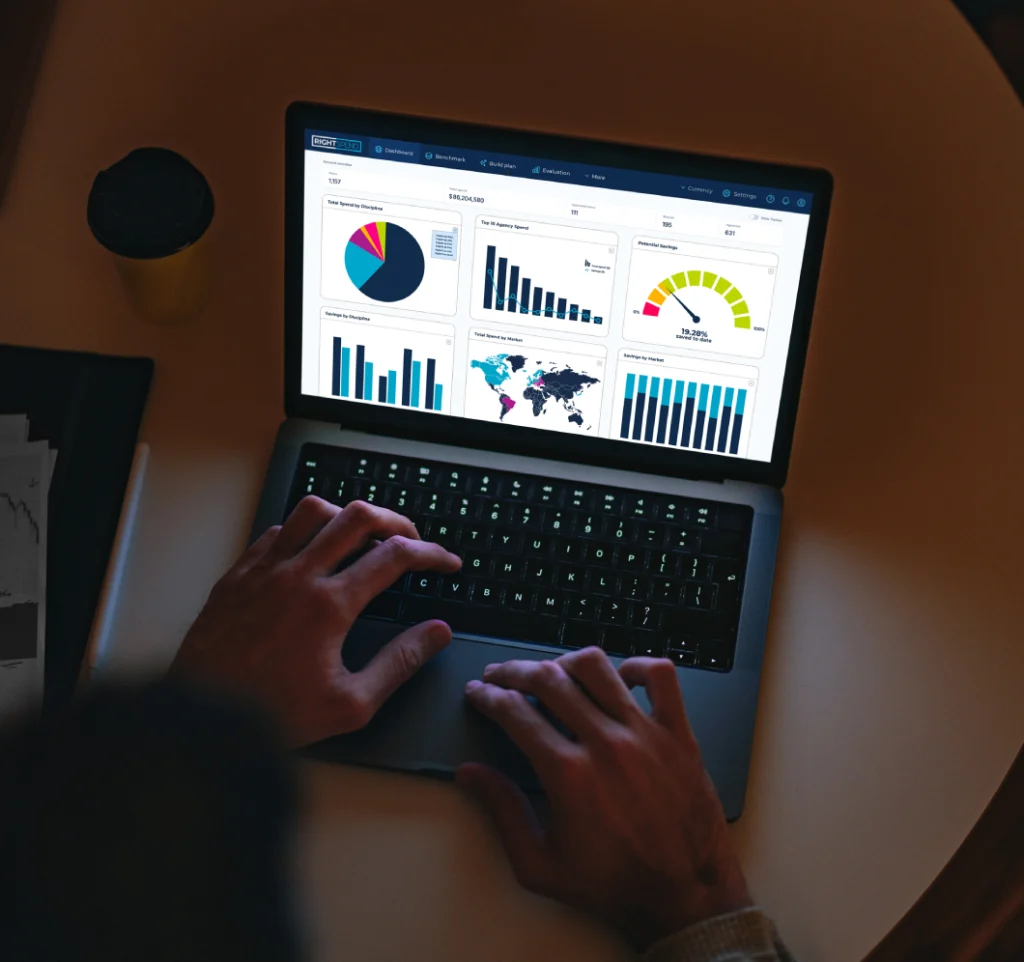 Hands on a laptop which has RightSpend open to review marketing budget data